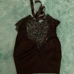 Small black top with some lace on the chest area. Ties around neck. Size small.